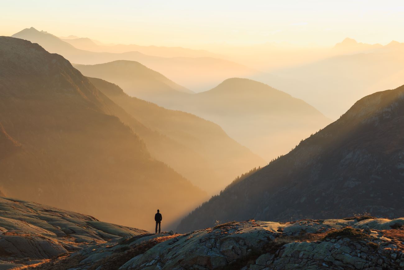 Person looking at the colorful layers of mountains at sunset